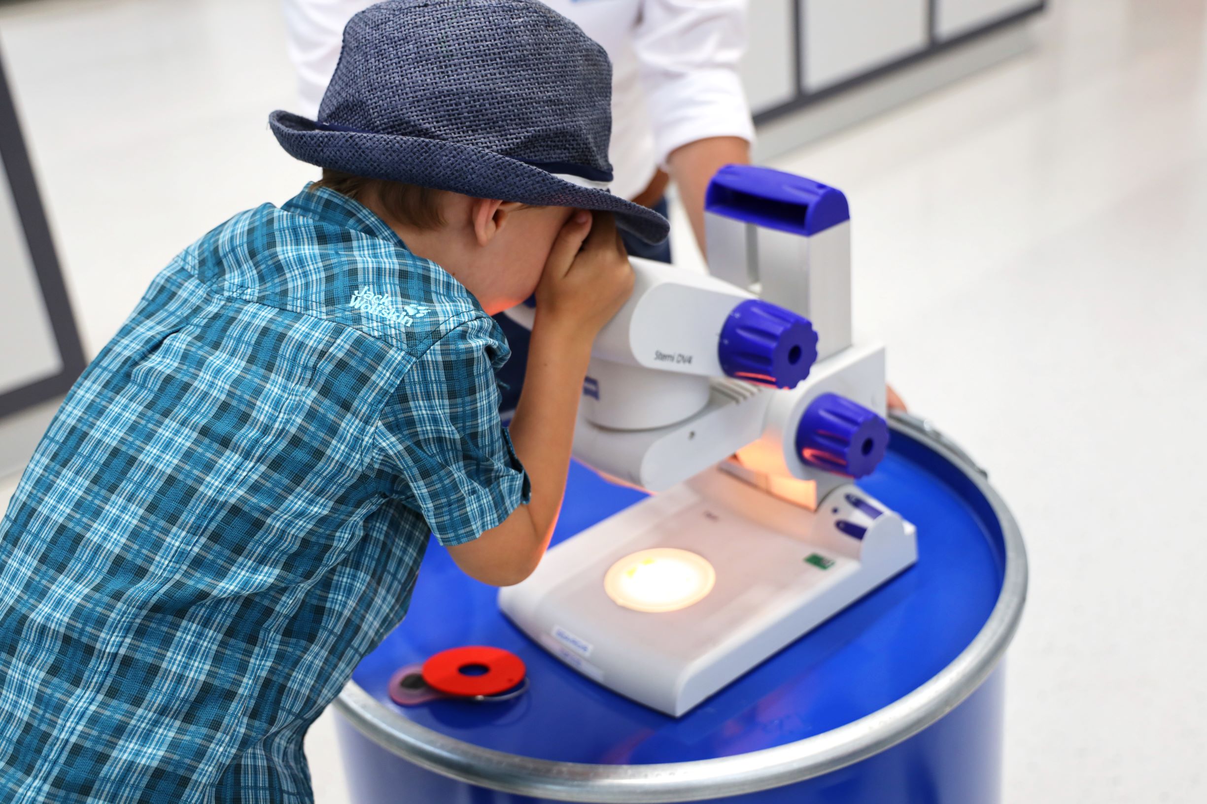 Lange Nacht der Forschung im sterner training center - Kind schaut durch Mikroskop